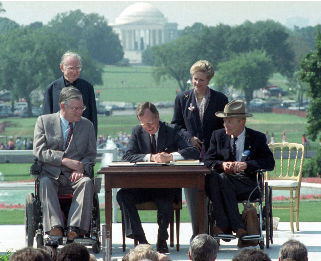 President George H.W. Bush signing the Americans with Disabilities Act into law in 1990, surrounded by disability rights advocates